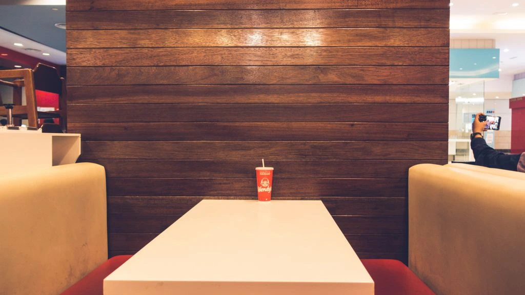 A quiet, wood-paneled clubhouse lounge at dusk — the room behind every argument on the forum.